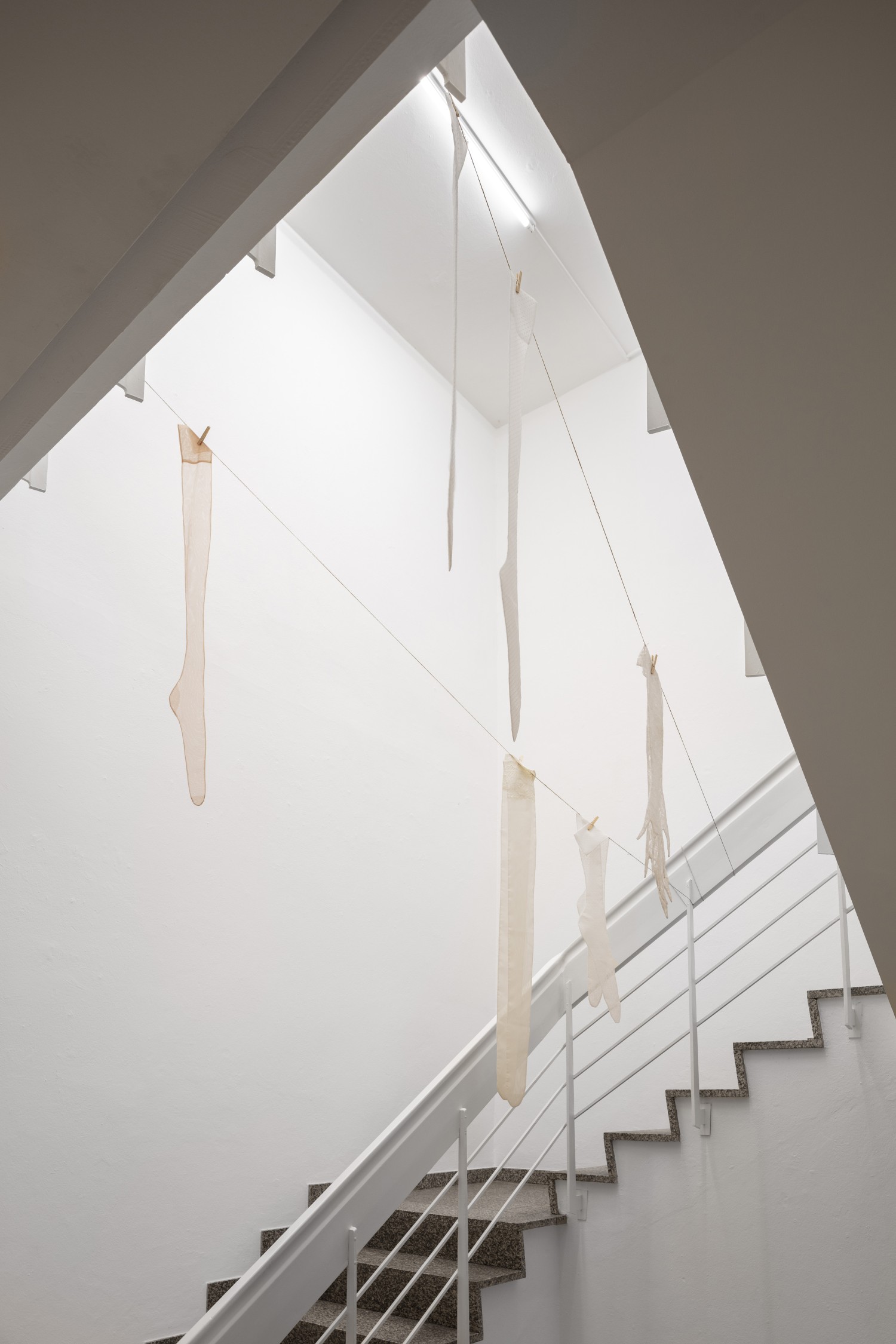 Im Treppenhaus des Kunstvereins hängen sechs übergroße Seidenstrümpfe von einer Wäscheleine. Julie Béna schafft mit der Arbeit "Le déshabillé" eine Irriation der Empfindung von Dimension und Raum.