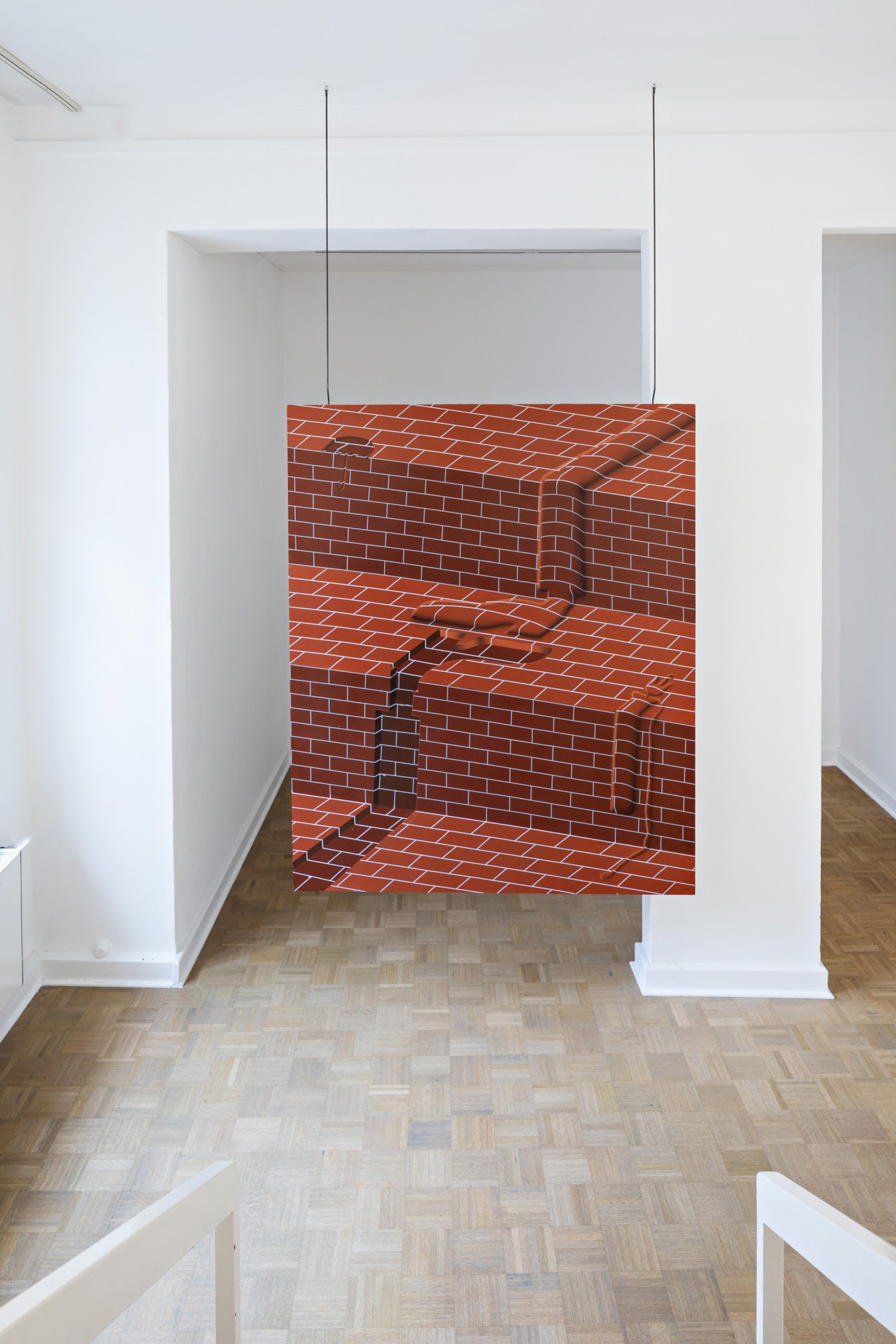 Das hängend installierte Werk zeigt ein Trompe-l’œil, also ein Gemälde welches aufgrund der angewendeten Technik dreidimensional wirkt.