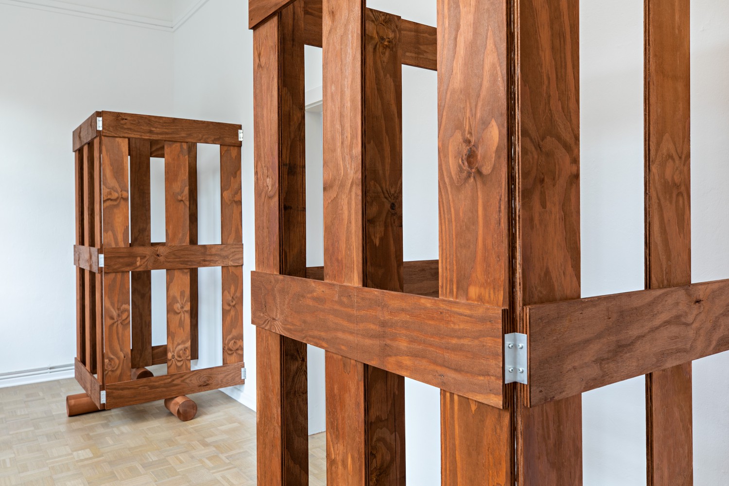 The two three-sided wooden gates on rollers in the small cabinet room look much more massive than the same gates in the larger otherwise empty exhibition rooms.  The close-up shows that the artist has placed the hinges that hold the gates together on the outside, making them visible to the viewer.